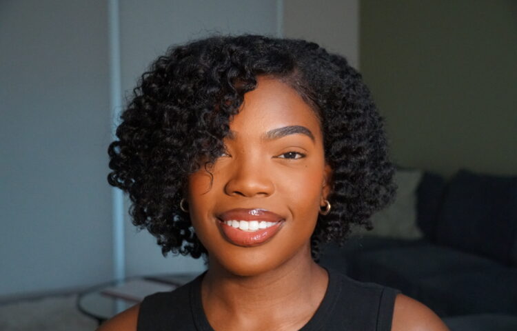 Black girl smiling with a voluminous, defined twist-out and side part.