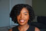 Black girl smiling with a voluminous, defined twist-out and side part.